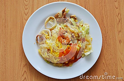 Stir fried rice noodle seafood and egg dressing chili sauce on dish Stock Photo