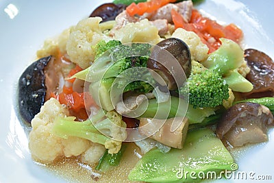 Stir fried slice cauliflower with broccoli and mixed vegetable couple pork on plate Stock Photo