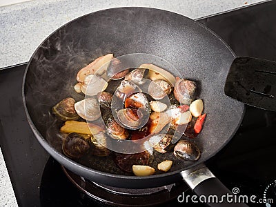 Stir-frying Ginger and clams at high heat to bring forth the savory aroma with sesame oil Stock Photo