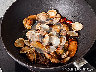 Stir-frying Ginger and clams at high heat to bring forth the savory aroma with sesame oil Stock Photo