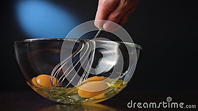 Stirring Eggs in a Glass Bowl with a Whisker Stock Photo