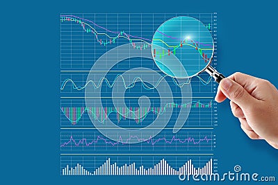 Stock Analysis concept hand holding magnifying glass trading graph Stock Photo