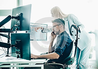 Stock broker business team trading online watching charts and data analyses on multiple computer screens in modern Stock Photo