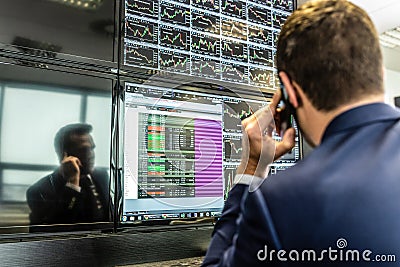 Stock broker trading online, talking on mobile phone. Editorial Stock Photo