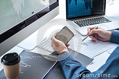 Stock exchange market concept, stock broker looking at graph working and analyzing with display screen, pointing on the data Stock Photo