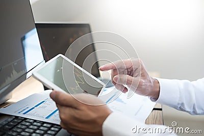 Stock exchange trader Analyzing Graphs chart or data On Multiple Screens in office Stock Photo
