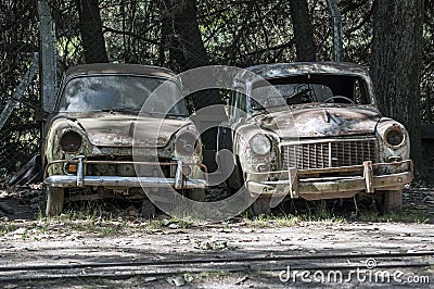 Stock image of two old, rusted, abandoned cars. Stock Photo