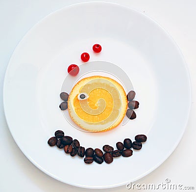 Food art. Little fish from fruit, creative idea for healthy breakfast on the white plate Stock Photo