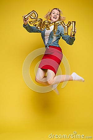 Cheerful girl with inflatable letters HAPPY.Stock photo portrait of attractive girl with red lips holding shining bright Stock Photo