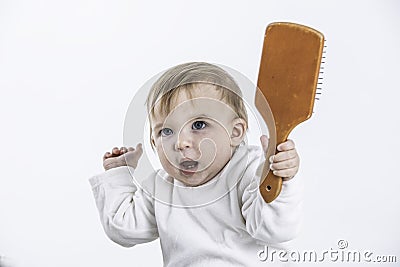 Studio photo with a white background of a baby with a comb in his hand Stock Photo