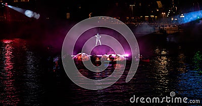 Hanging acrobat with the performance below in purple light Editorial Stock Photo