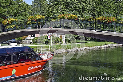 Commuter ferry boat of Stockholm in the Royal Chanel Tour, passing beneath the bridge, as seen from Djurgarden island Editorial Stock Photo