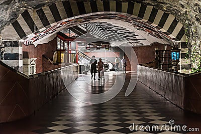 Stockholm, Sweden - Decorated interior of the underground metro with a young couple walking through the isle Editorial Stock Photo