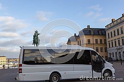 Minibus on the background of the Statue of Charles XIV Johan in Stockholm on the square in Editorial Stock Photo