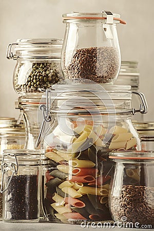 Stocks or set of cereals, pasta, groats, organic legumes and useful seeds in glass jars. Vegan source of protein and energy Stock Photo