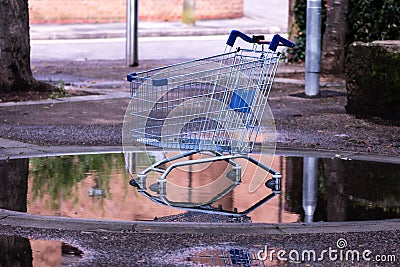Stolen shopping cart left on the street, abandoned shopping trolley in a paddle Stock Photo