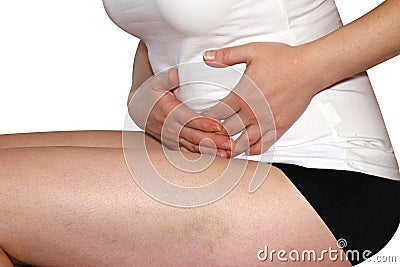 Stomachache. Woman having painful stomachache, first signs of pregnancy, close-up, white background Stock Photo