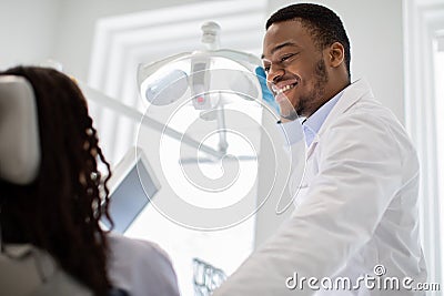 Stomatological Treatment. Black Dentist Doctor Making Check Up To Female Patient Stock Photo