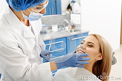 Stomatologist checking oral cavity of client after treating teeth Stock Photo