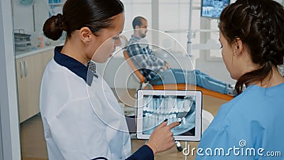 Stomatologist holding modern tablet with x ray on screen Stock Photo