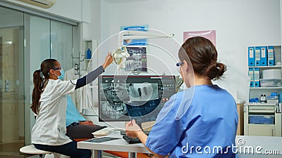 Stomatologist nurse comparing radiographics looking at computer Stock Photo