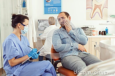 Stomatologist nurse explaining medical procedure to sick patient Stock Photo