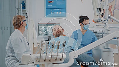 Stomatologist and nurse finishing oral care procedure with patient Stock Photo