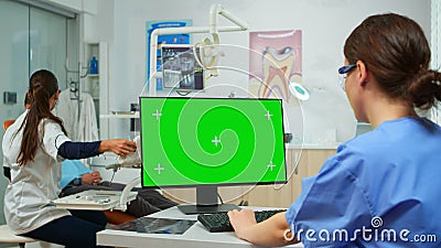 Stomatologist nurse looking at green screen tablet Stock Photo