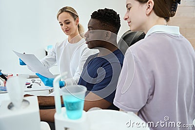 Stomatologist showing to African American client x-ray image of his jaw Stock Photo