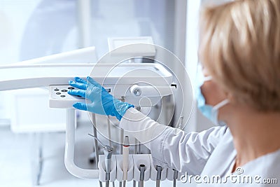 Stomatologist turns on dental machine to make teeth treatment Stock Photo