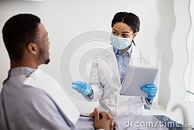 Stomatologist Woman With Digital Tablet In Hands Consulting Male Patient Stock Photo