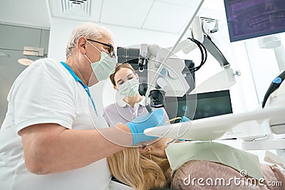 Stomatologist working with female patient and tools Stock Photo