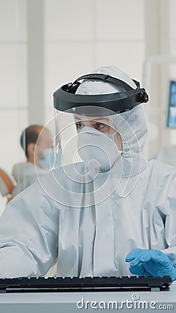 Stomatology assistant sitting at desk using computer Stock Photo