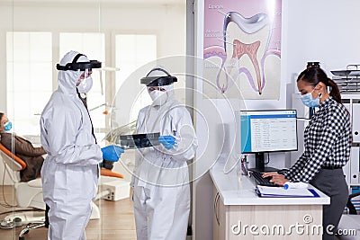 Stomatology assistant wearing face shiled ppe suit Stock Photo