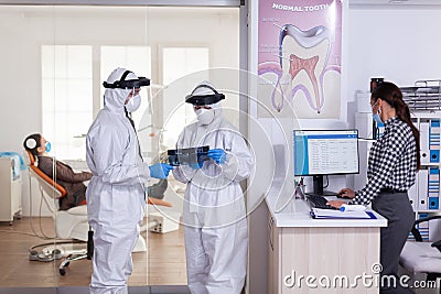 Stomatology assistant wearing face shiled ppe suit Stock Photo