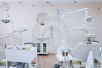 Stomatology interior of small dental clinic with professional chair in green colors. Dentistry, medicine, medical equipment and Stock Photo