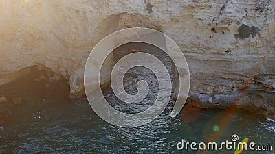 Stone arch in sea water. Sunlight makes a highlight. Natural roughness. Stock Photo