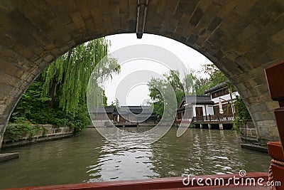 stone arch of water bridge overlooking old buildings Editorial Stock Photo