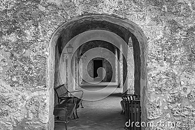 Stone archways leading into walkway in black and white Stock Photo