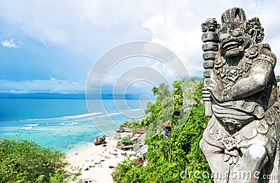 Stone balinese statue Blue sea sky tropical sand beach Stock Photo