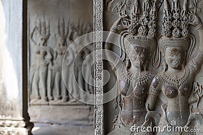 Stone bas-relief with human figure in Angkor Wat, Siem Reap, Cambodia. Devata bas-relief closeup in ancient temple. Stock Photo