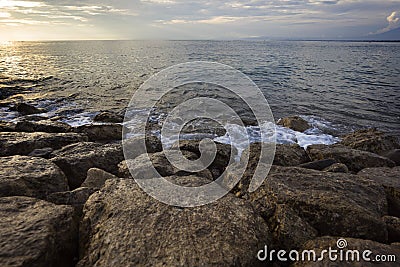Stone beach hit by sea waves on the coast of Bali. Isolated on the concept of environment and earth hour Stock Photo