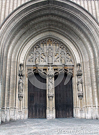 Large stone beautiful door with gothic elements and statues in the Catholic Church Editorial Stock Photo