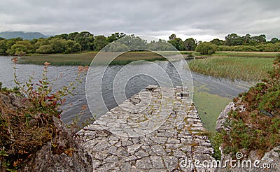 Stone boat dock of ancient castle ruins McCarthy Mor on Lake Lough Leane at Killarney on the Ring of Kerry in Ireland Stock Photo