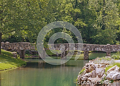 Stone bridge with leafy trees and rocks Editorial Stock Photo