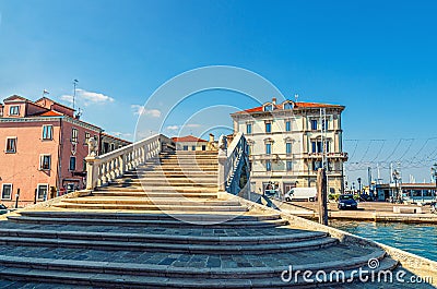 Stone bridge Ponte di Vigo with stairs across Vena water canal and old buildings in historical centre of Chioggia Stock Photo