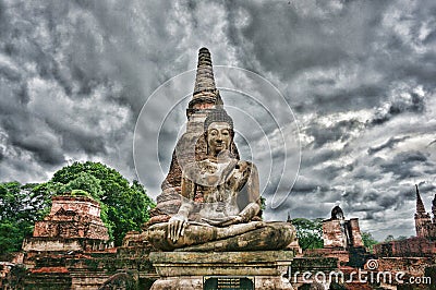 Stone Buddha sitting in front of a pagoda Stock Photo