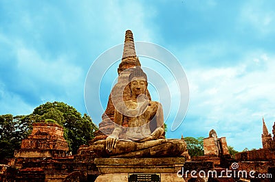 Stone Buddha sitting in front of a pagoda Stock Photo