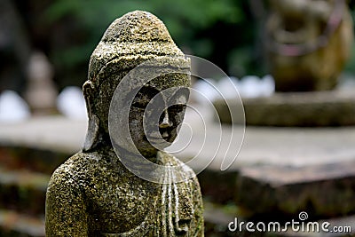 Stone Buddha statue with moss close up Stock Photo