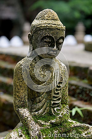 Stone Buddha statue with moss close up Stock Photo